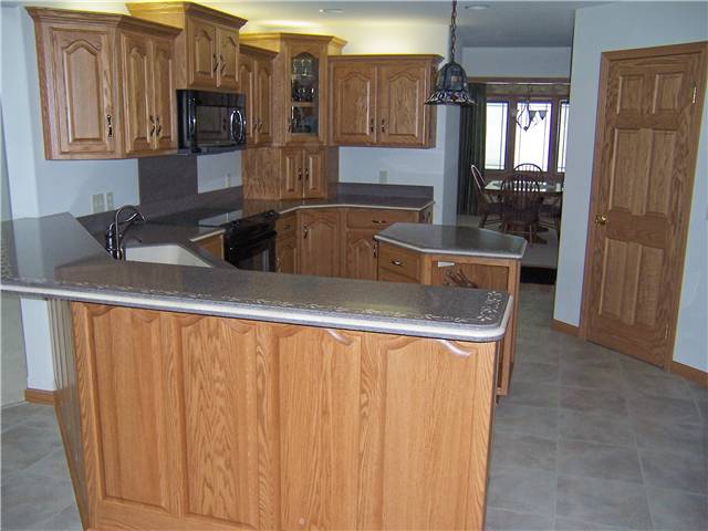 Red oak cabinets - Raised panel doors and side panels - Standard overlay style - Solid surface countertops
